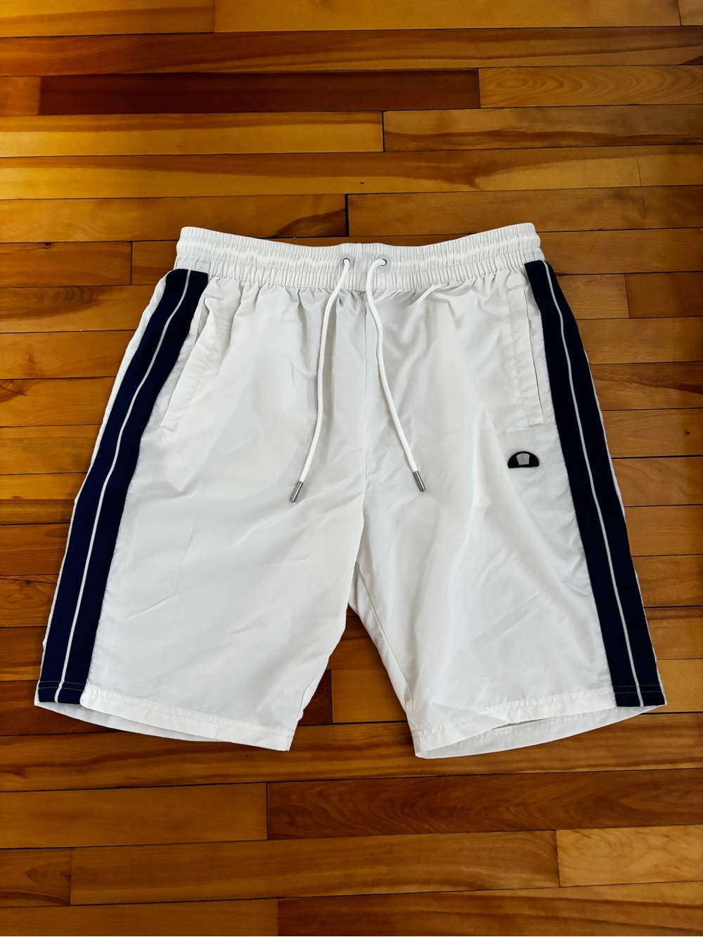 Ellesse white shorts with navy blue side stripes